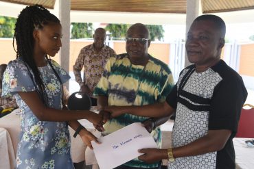 Congraluations, Naa...that's what Mr Ayibor, headmaster of Ada Senior High, says as he hands over a cheque to Naa Kuorkor Afutu. With them is Dr Canacoo, chairman of the Board of Trustees.